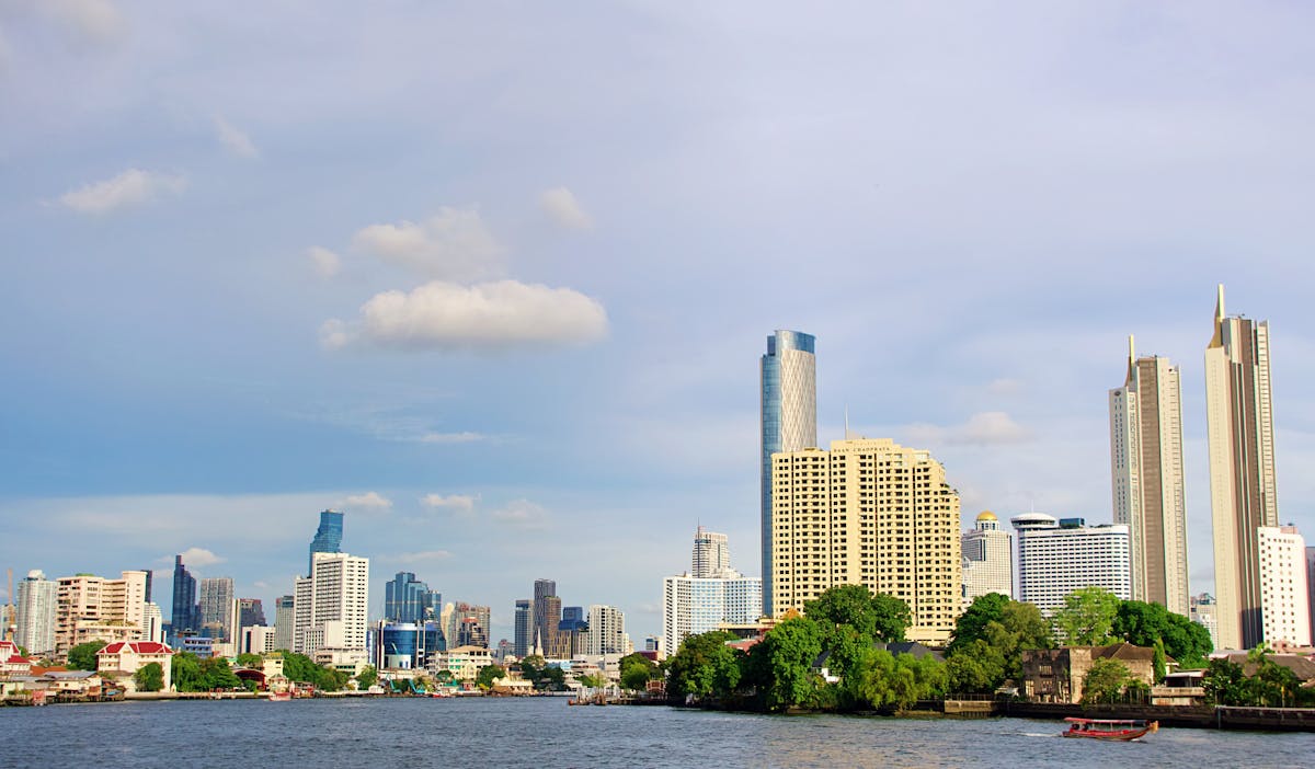 Modern Bangkok skyline along the Chao Phraya River under clear blue sky