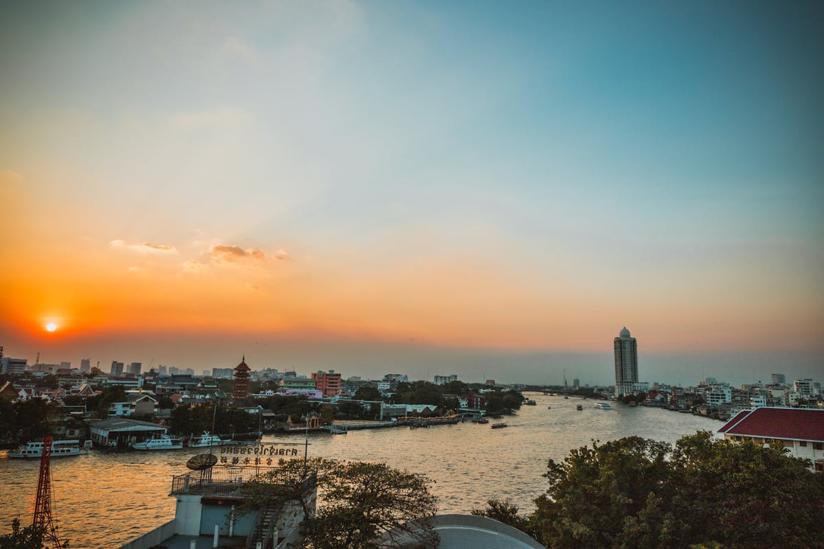Golden sunset over the Chao Phraya River in Bangkok with city skyline
