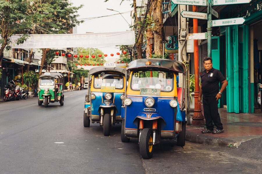 Colorful tuk tuks parked along a Bangkok street