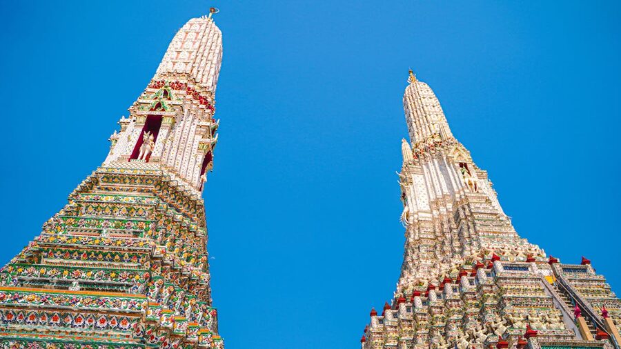 Low angle view of Wat Arun ornate tower against clear blue sky in Bangkok