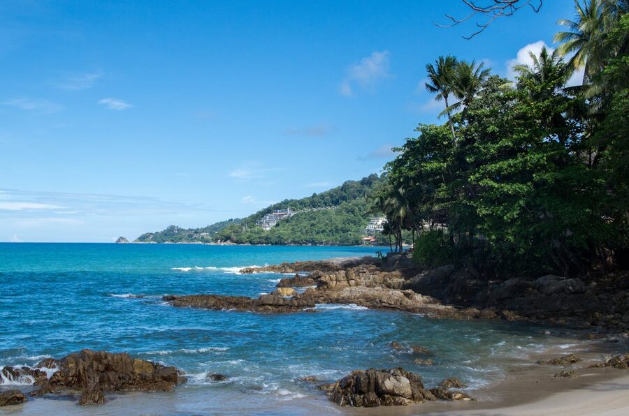 Tropical coastline with clear blue sea and lush greenery in Phuket Thailand