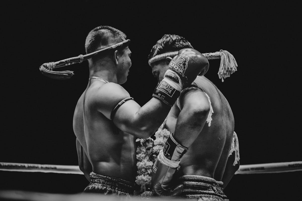 Black and white photo of two Muay Thai fighters in a ring showing sport intensity