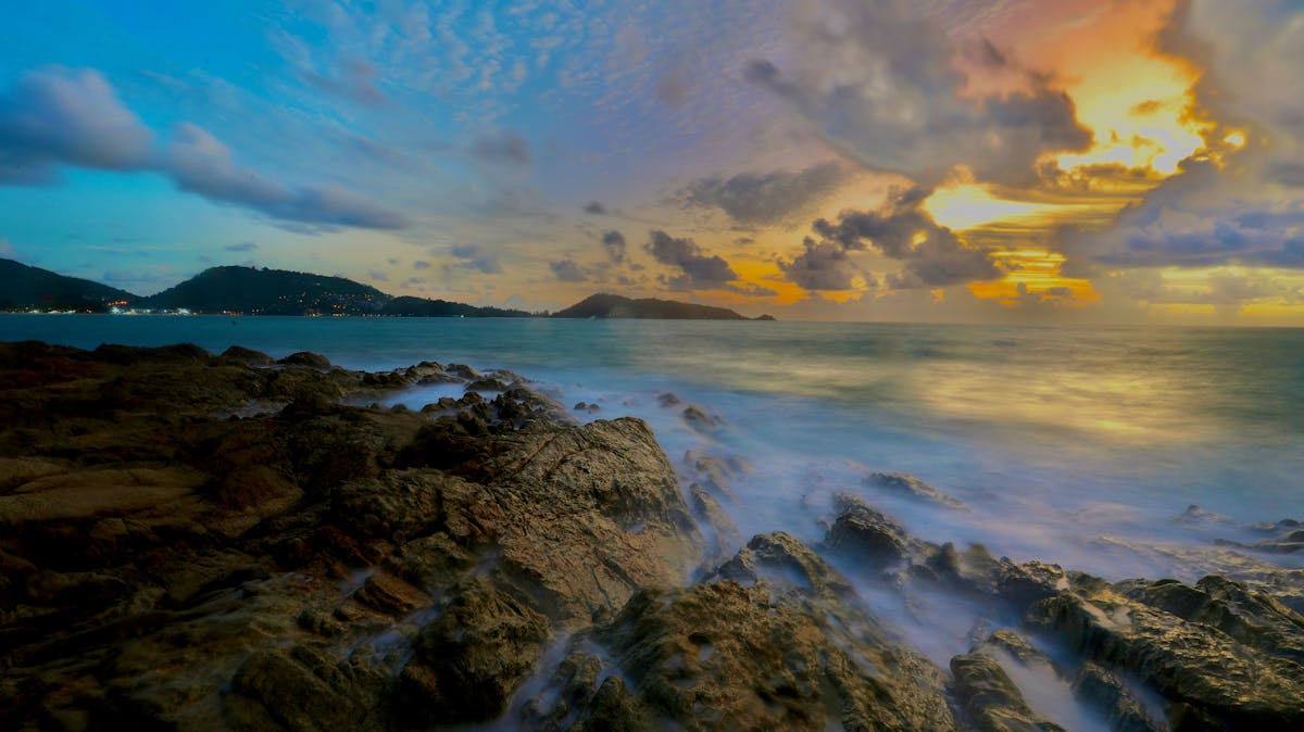 Serene sunset view over rocky coastline at Patong Beach Phuket Thailand