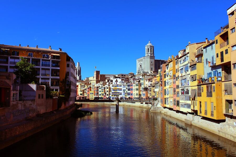 Pedestrian bridge over the Onyar River with Girona's old town behind
