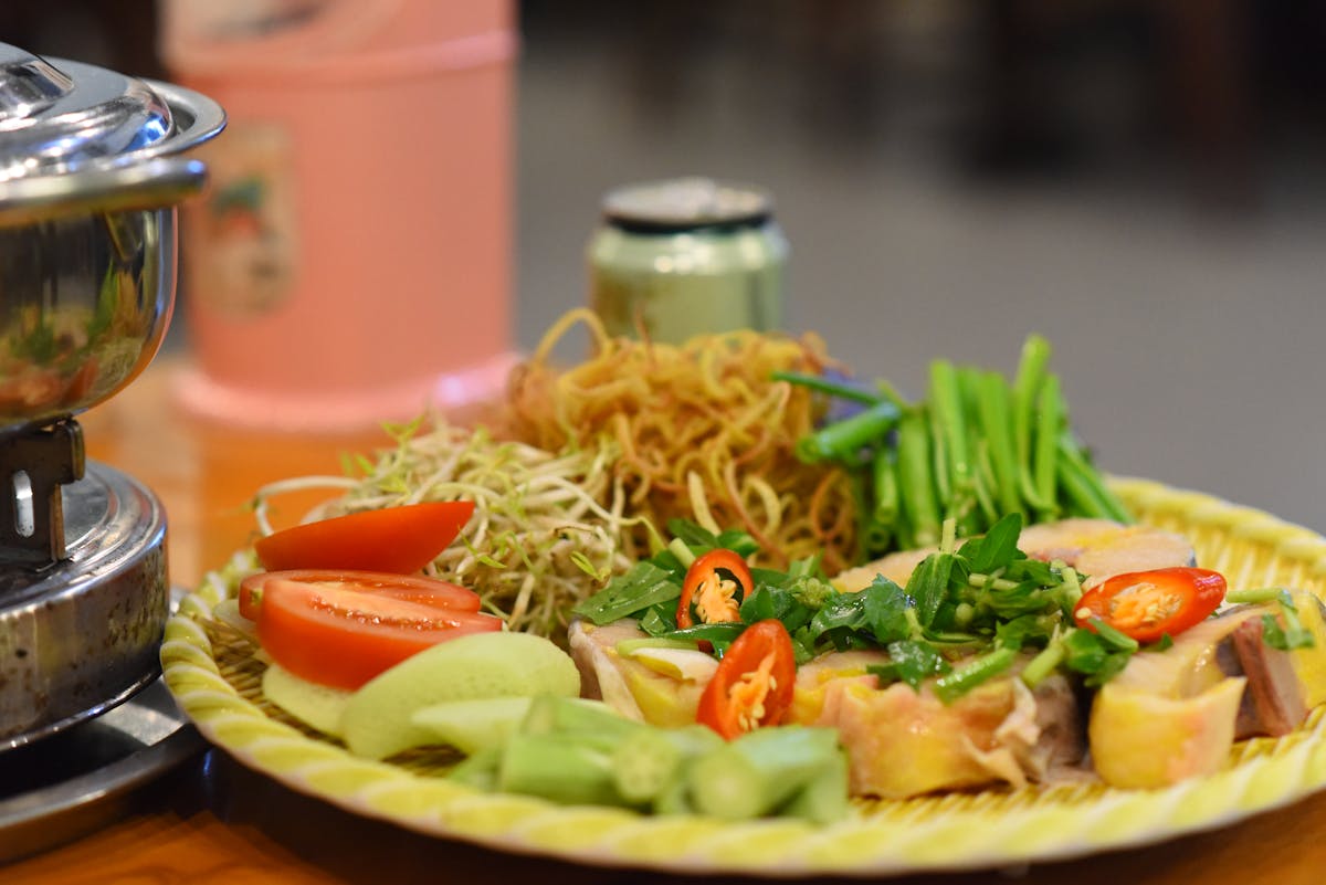 Colorful Vietnamese meal featuring noodles vegetables and fresh herbs