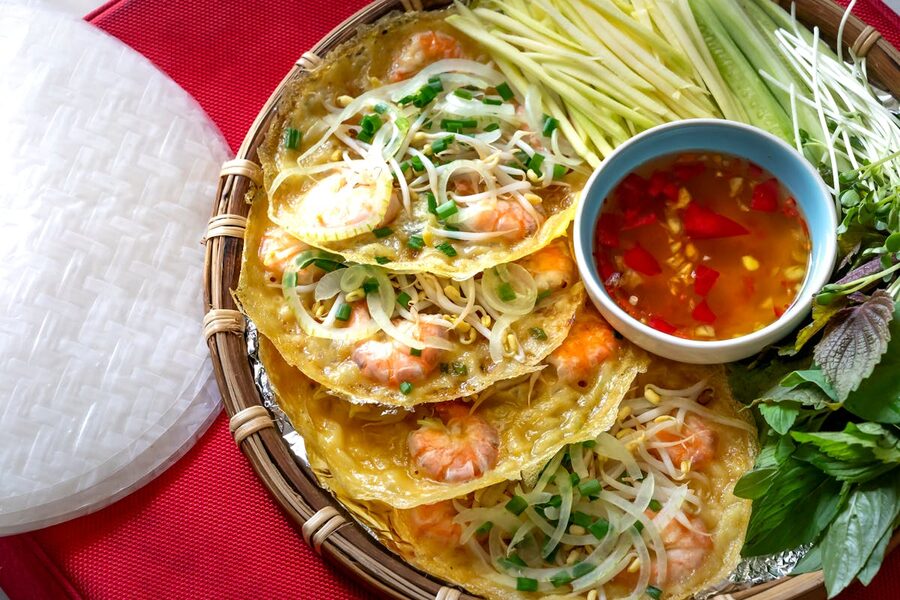 Traditional Vietnamese crispy pancake banh xeo served with fresh vegetables and dipping sauce
