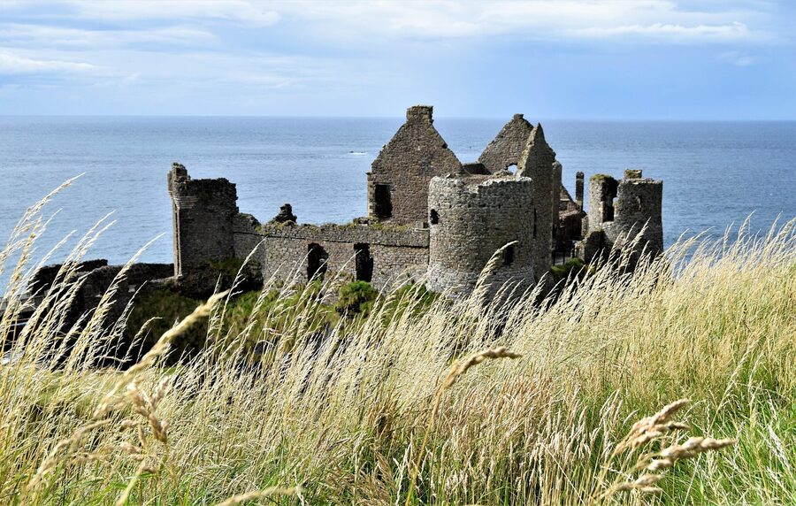Dunluce Castle ruins from the wider Antrim coastline showing the dramatic clifftop position