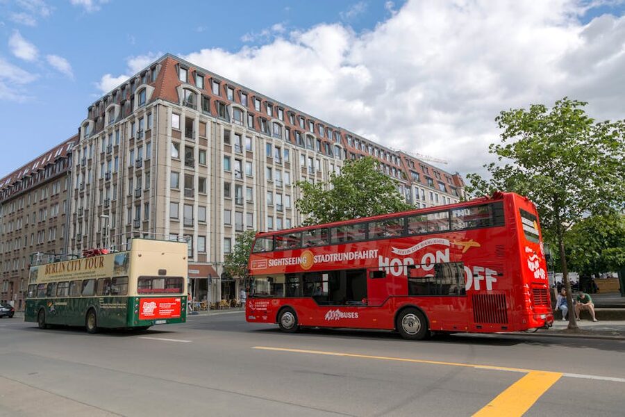 Berlin sightseeing tour buses near a historic building on a clear day