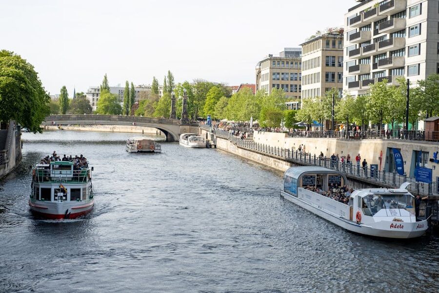 Sightseeing boat cruising the Spree past green riverbanks in Berlin