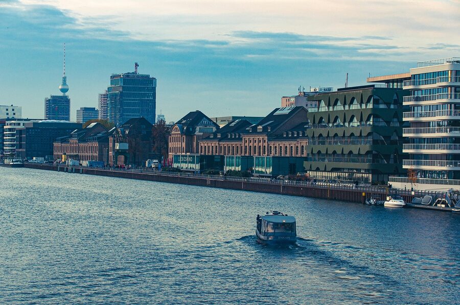 Berlin Spree River with sightseeing boat passing modern riverside buildings