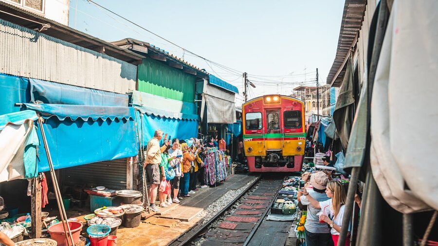 Close view of train navigating through the crowded railway market stalls
