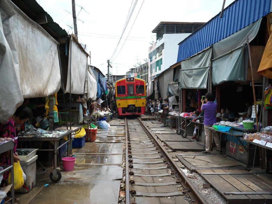 Train passing through Maeklong Railway Market stalls in Thailand