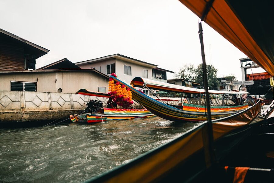 Colorful longtail boats navigating a canal in Bangkok Thailand