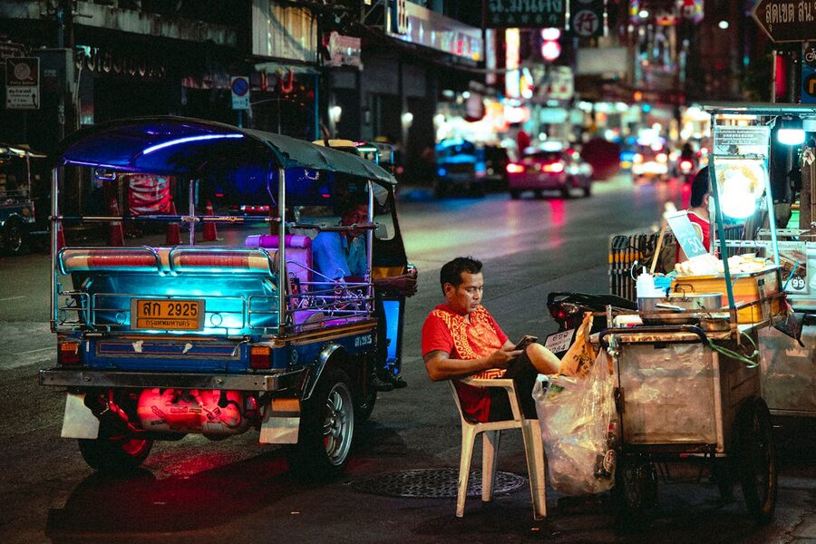 Colorful night scene of a street vendor and tuk-tuk in Bangkok Thailand