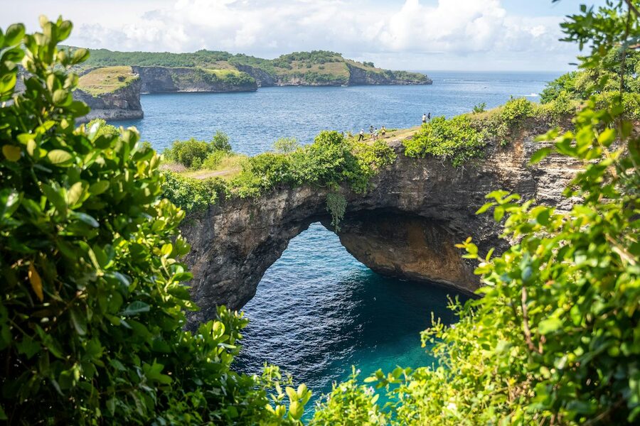 The natural stone arch and round cliff crater of Broken Beach on Nusa Penida's west coast