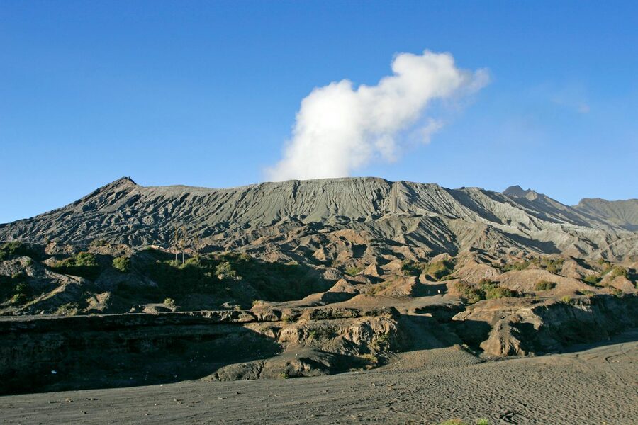 Mount Bromo caldera at dawn with steam rising from the volcano