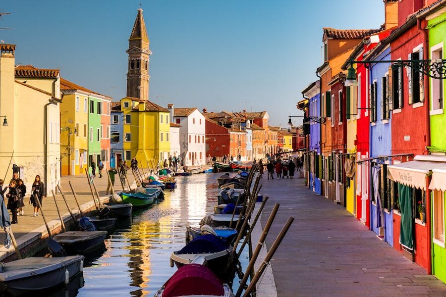 Burano boats reflected in canal showing the colorful facades