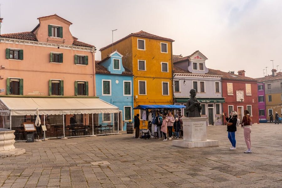 Burano main square with bust statue and tourists exploring