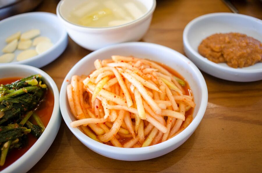 Assortment of Korean side dishes displayed on a wooden table