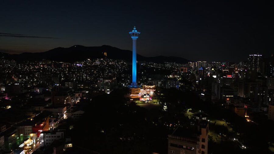 Busan Tower illuminated at night above the city skyline