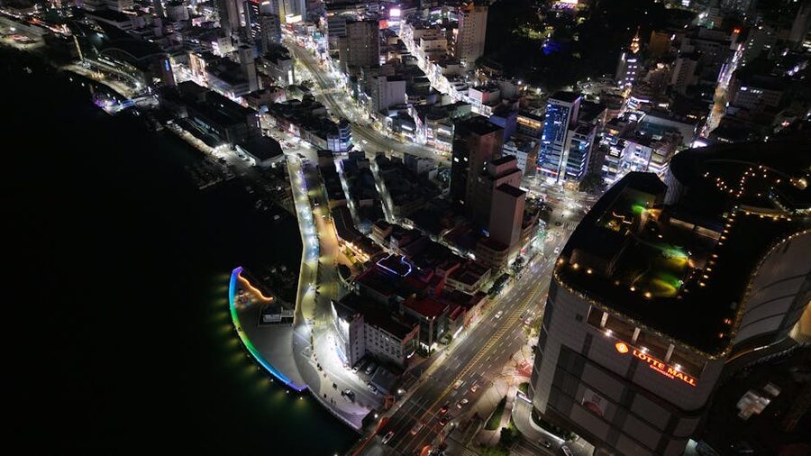 Busan cityscape at night with illuminated streets and buildings from the air