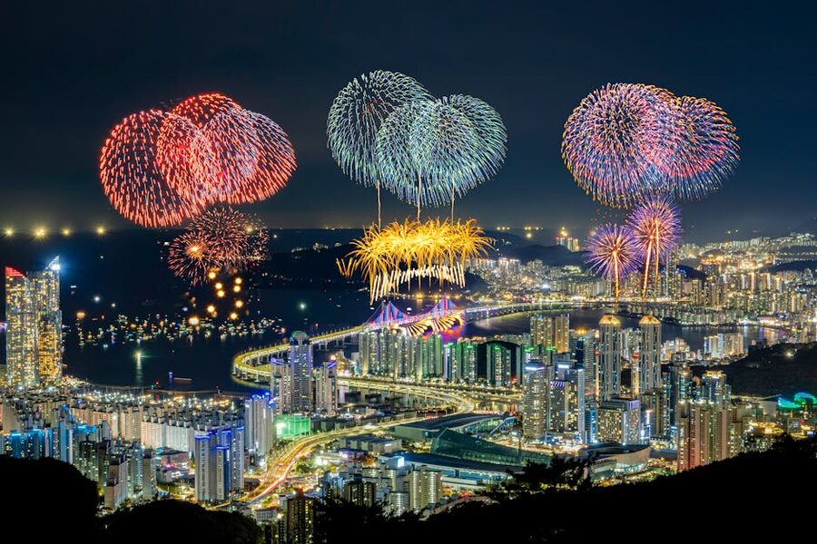 Fireworks over Busan skyline at night with illuminated buildings