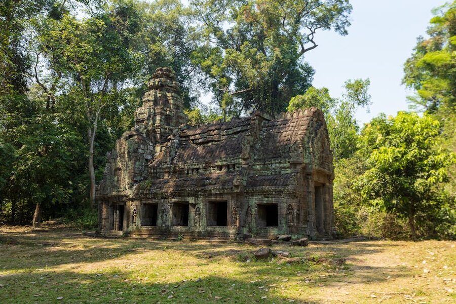 Cambodia pagoda on hilltop with temple roof and palm trees