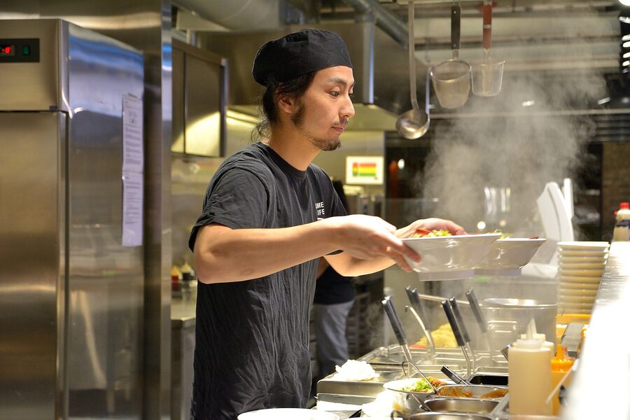 Chef serving ramen with noodles on plate