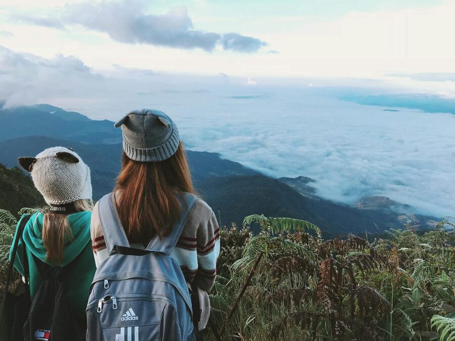 Two hikers with backpacks overlooking mountain clouds near Chiang Mai
