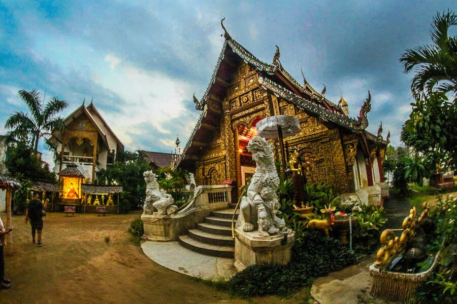 Beautifully decorated Thai temple entrance with sculptures at dusk in Chiang Mai