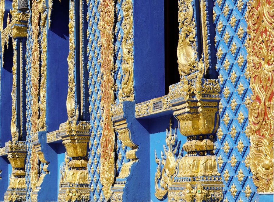 Intricate blue and gold temple facade at Wat Rong Suea Ten in Chiang Rai