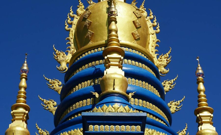 Ornate blue and gold stupa at Wat Rong Suea Ten Blue Temple Chiang Rai