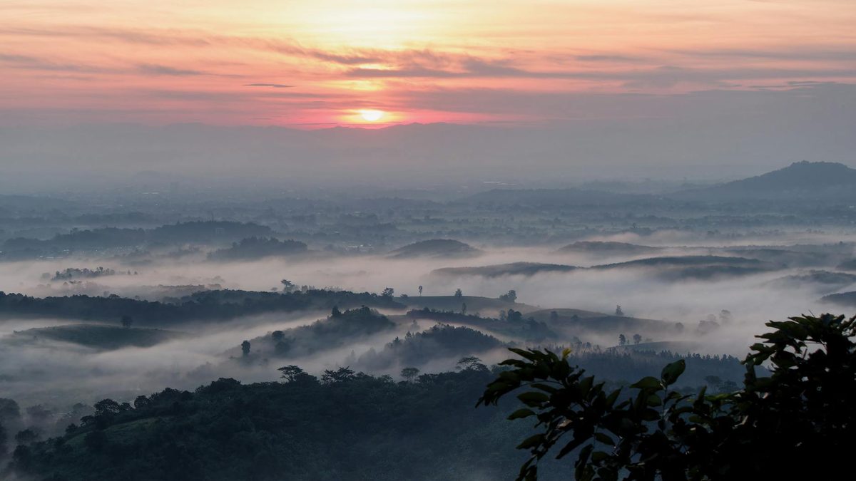 Fog covering hills at sunrise near Chiang Rai Thailand