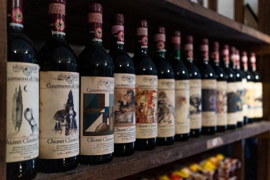 Chianti Classico wine bottles on a cellar shelf with the black rooster seal