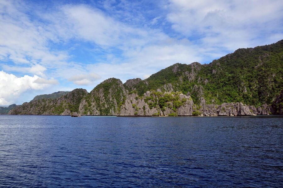 Rocky limestone cliffs and blue ocean in El Nido Philippines