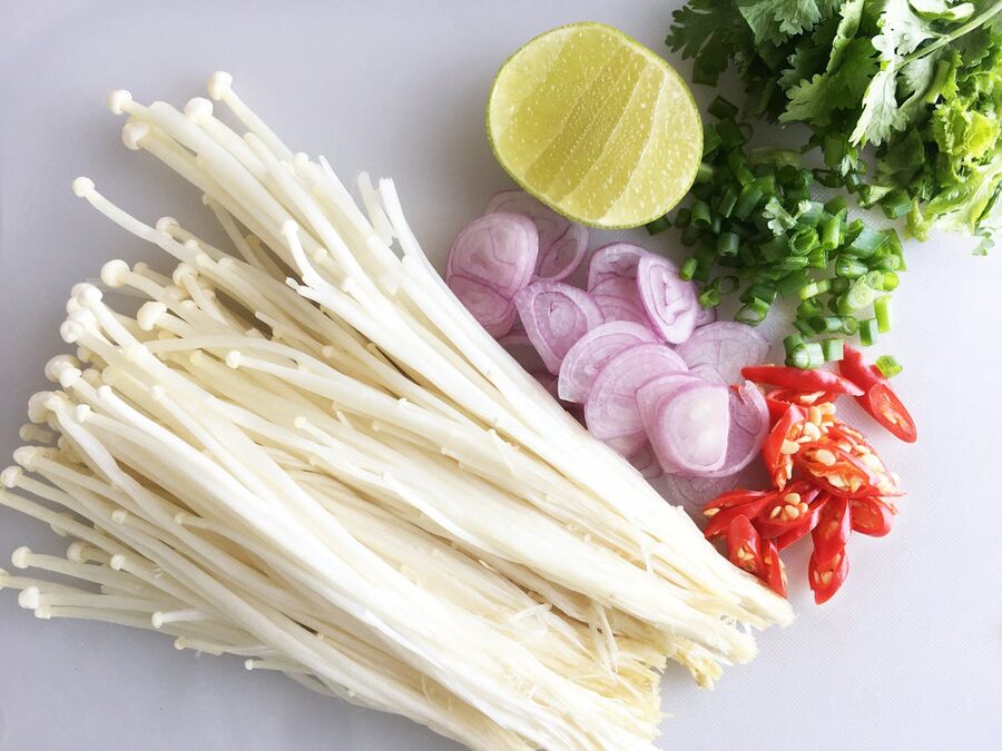 Fresh Thai cooking ingredients including mushrooms, lime, and chili peppers