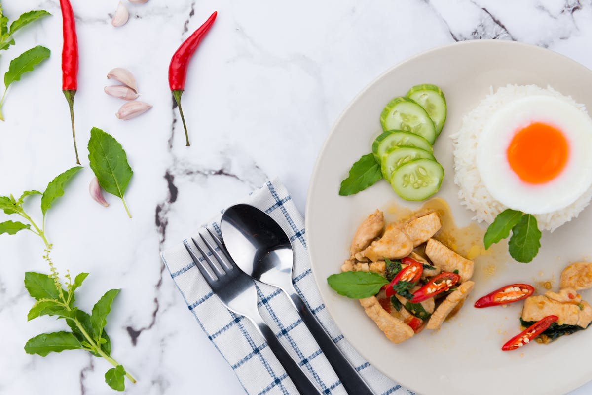 Close-up of a Thai meal with rice, chicken, and vegetables