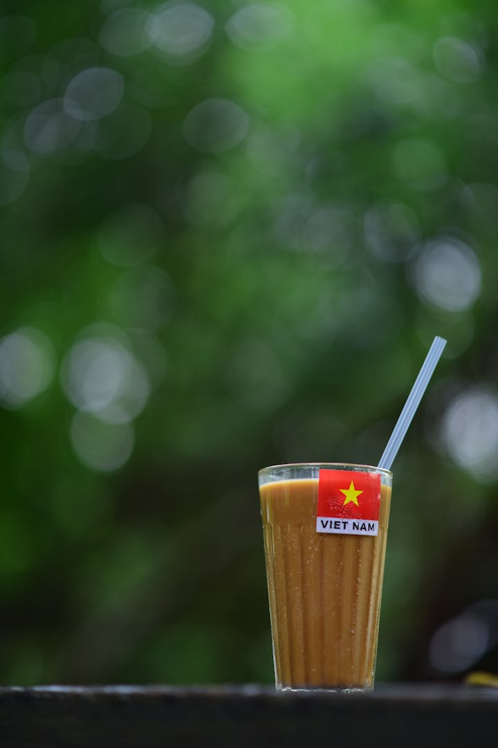 A small traditional Vietnamese coffee shop with wooden tables and a phin brewing on each