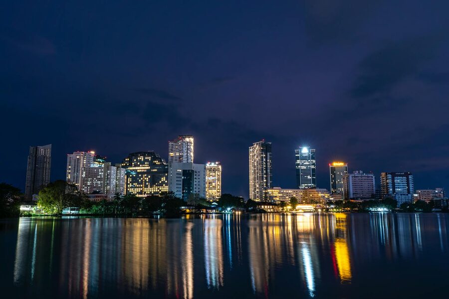Colombo city skyline illuminated at night reflected in the water