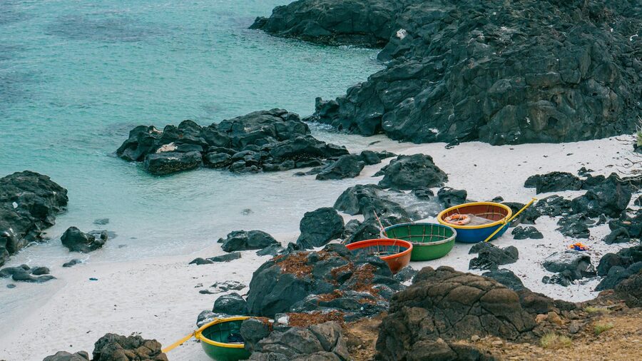 Colorful basket boats resting on a shore in Vietnam