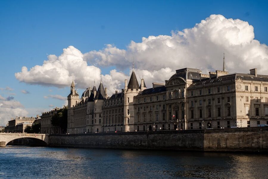 Conciergerie palace by the Seine River in Paris under a bright blue sky