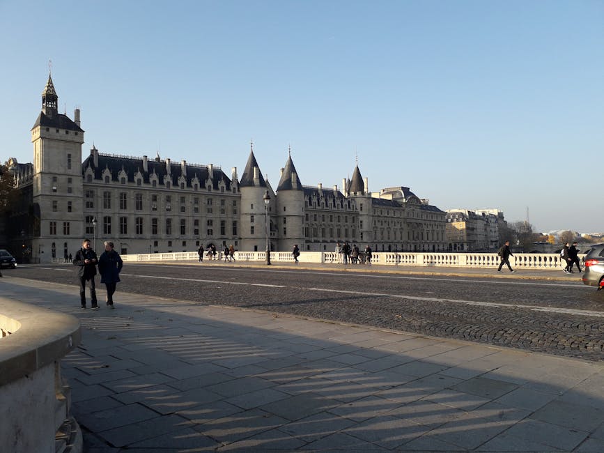 Conciergerie palace exterior with pedestrians on the Seine quayside