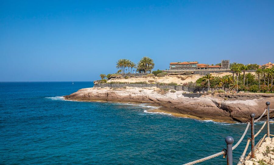 Rocky volcanic coastline at Costa Adeje, Tenerife with clear blue water