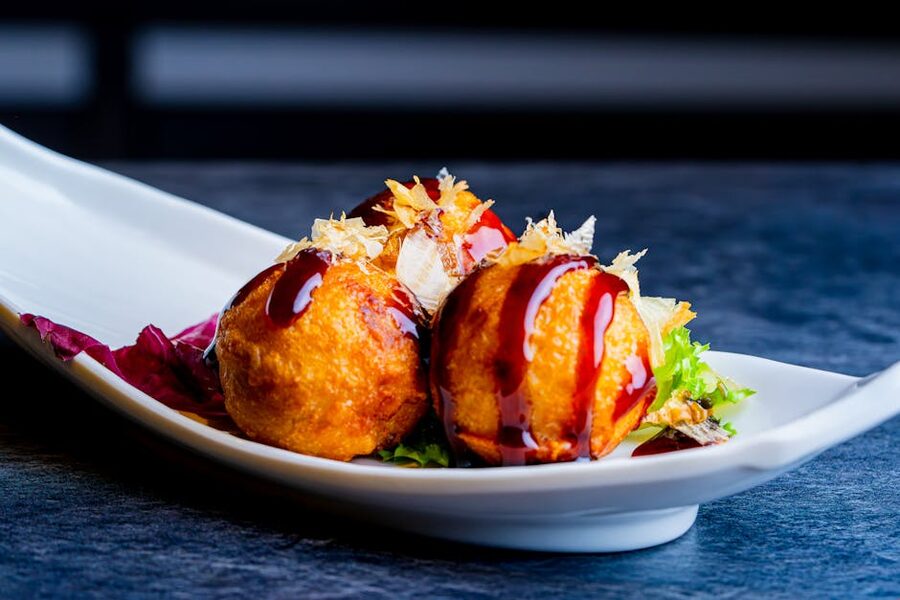 Crispy takoyaki balls drizzled with sauce