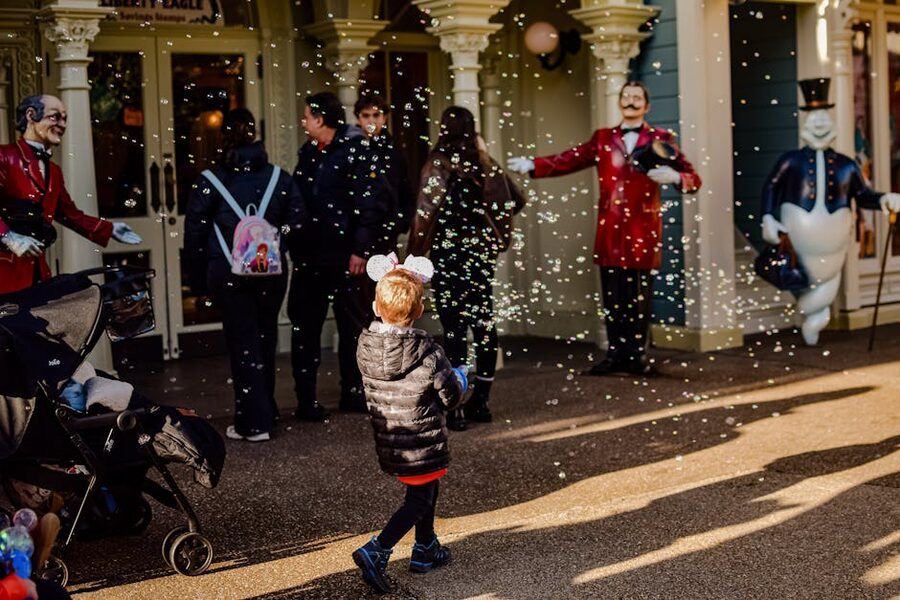 A child wearing Mickey Mouse ears at Disneyland Paris with bubbles in the air