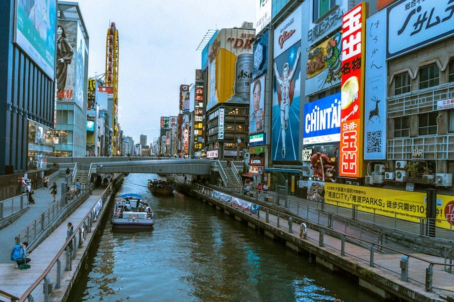 Dotonbori Canal with billboards and people strolling along walkway Osaka