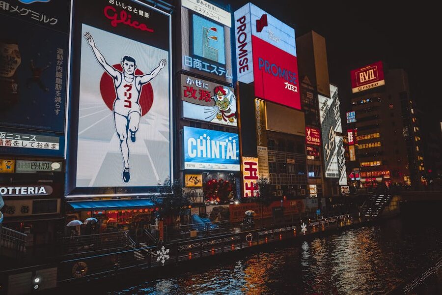 Neon signs reflecting on Dotonbori River at night in Osaka