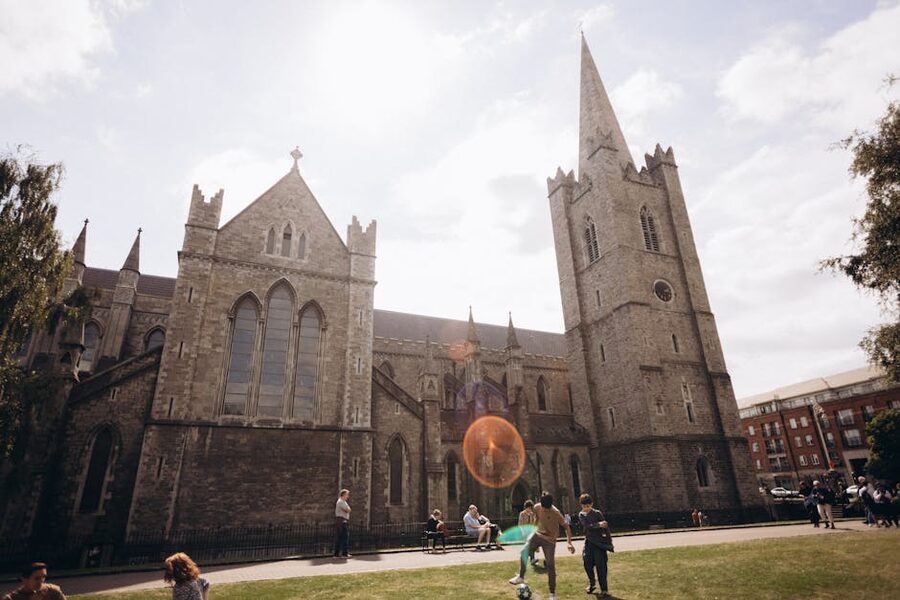 St Patrick's Cathedral Dublin with people in the surrounding park on a sunny day