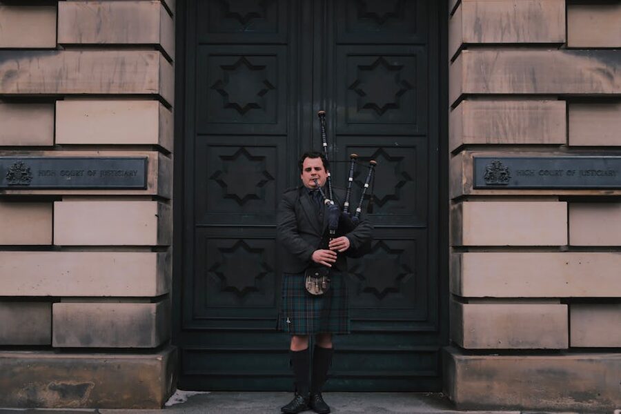 Bagpiper in tartan playing on the Royal Mile