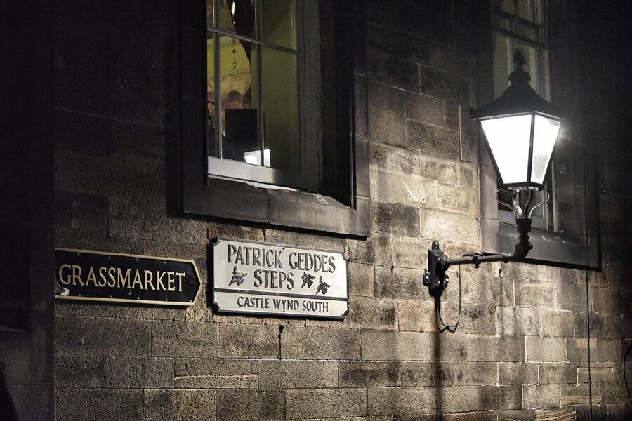 Grim mystical Edinburgh Old Town at night with street lamp